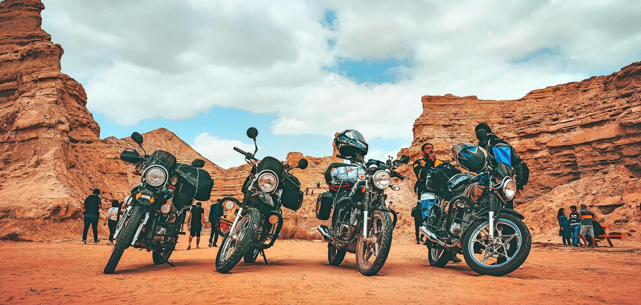 Riders taking a break between red rock canyons, capturing the spirit of freedom and exploration on the open road.